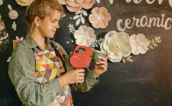Woman in Apron Labeling Handmade Cup