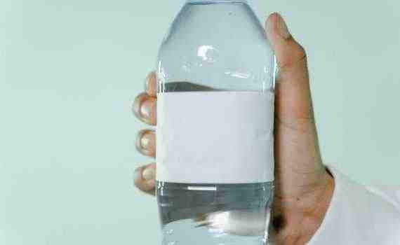 A Person Holding a Water Bottle with a Blank Label