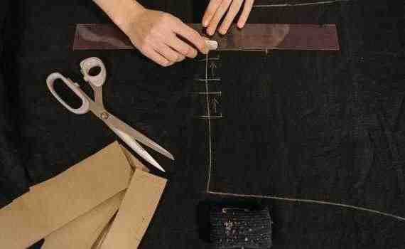 Person Putting Markings on a Black Fabric