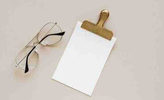 Composition of glasses and clip on beige background