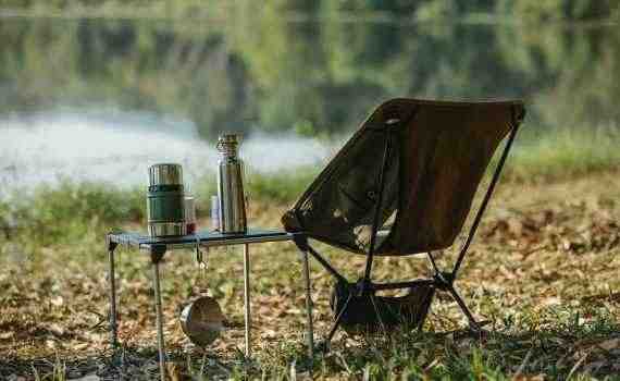 Camping chair near table on river shore