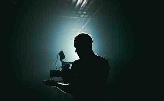 Silhouette of Man Standing in Front of Microphone