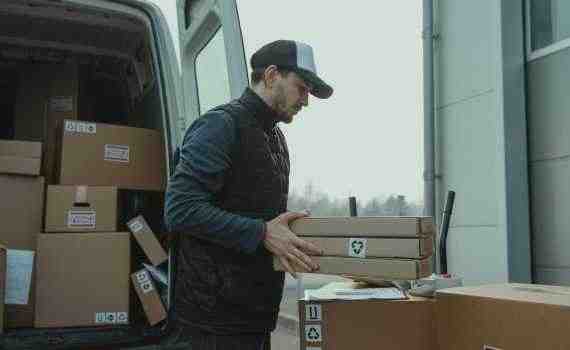 Man Checking the Paper while Carrying the Packages